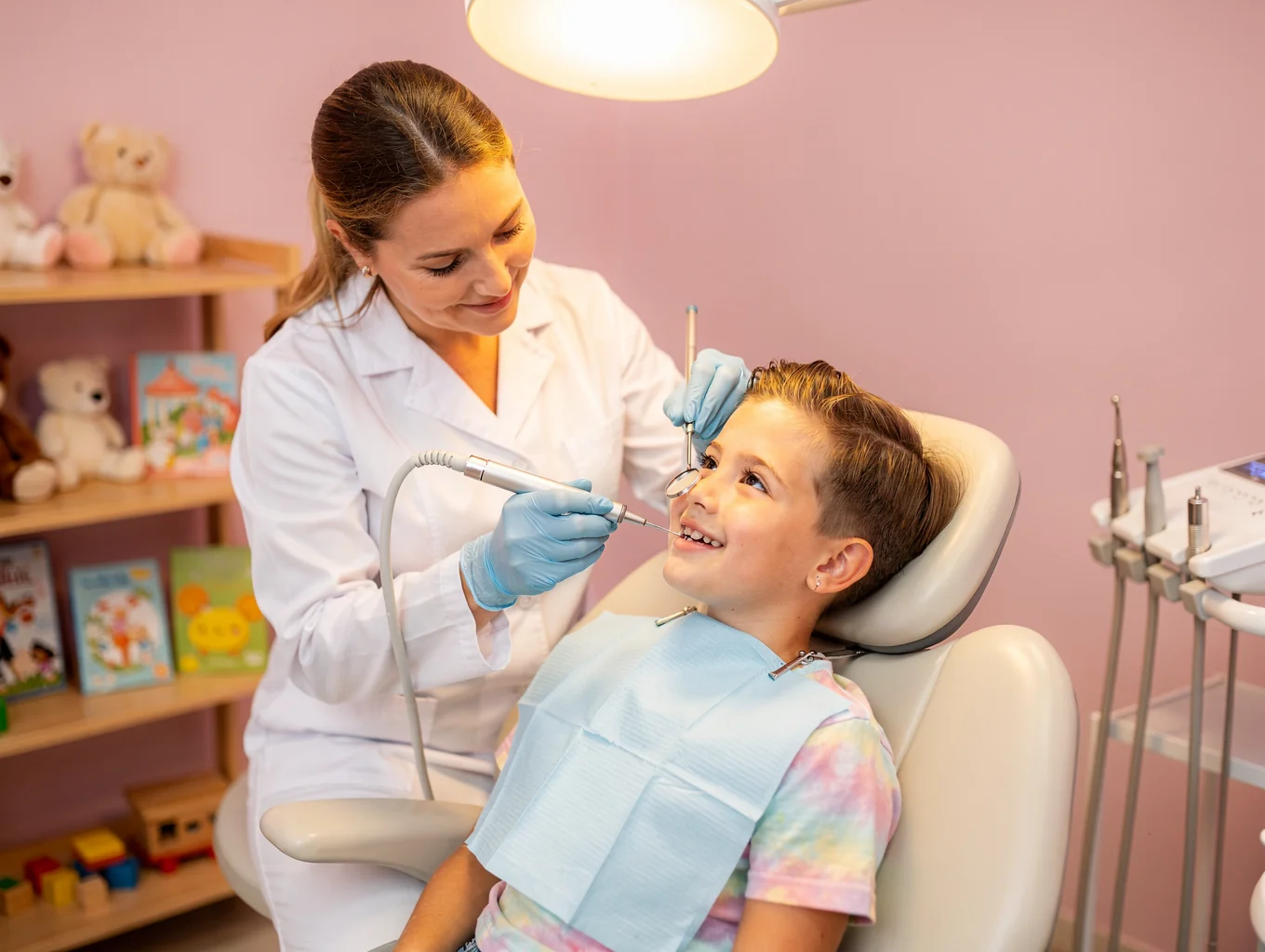 Friendly dental hygienist interacting gently with young patient